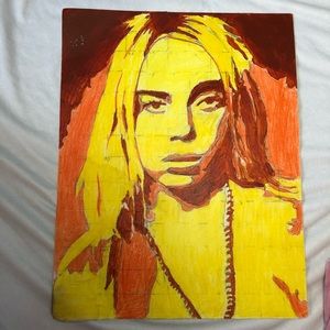 It’s yellow and orange portrait of Billie Eilish handmade with paint and crayons